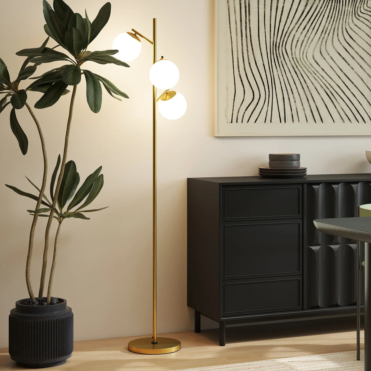 Gold-tone floor lamp with three white globe shades and slim round base