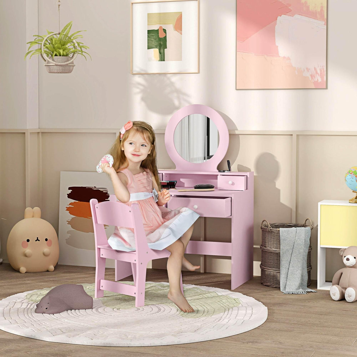 Kids pink makeup vanity set with round mirror and matching stool, child seated with feet on rug