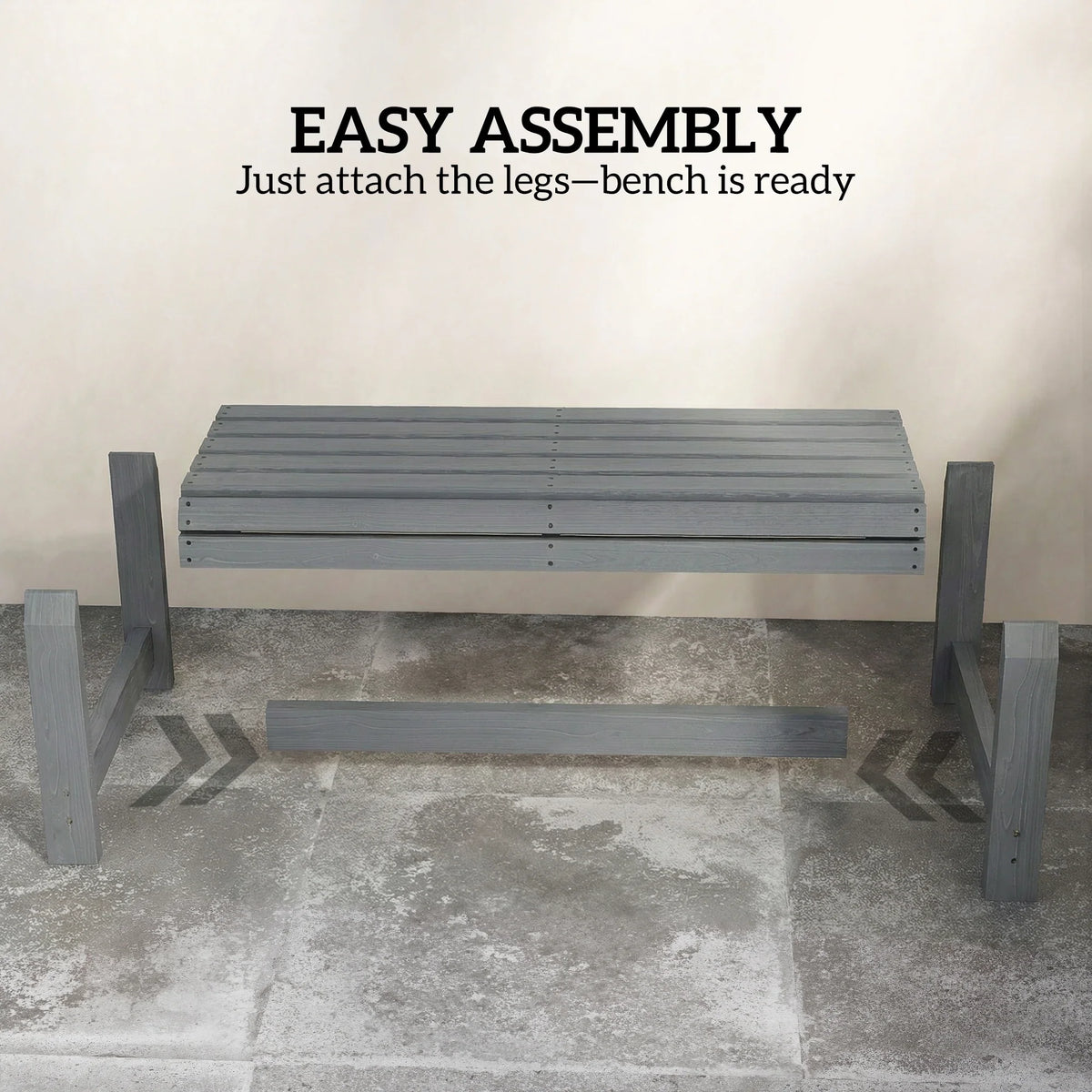 Grey backless wooden outdoor bench, slatted seat across, four sturdy legs for stability.