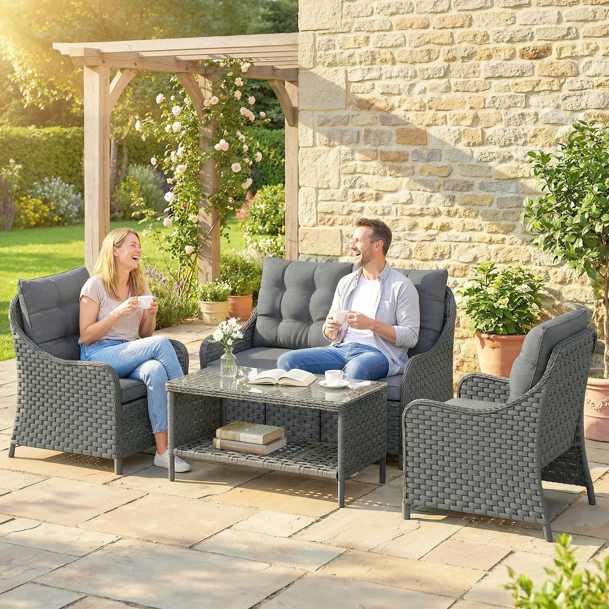 Dark grey woven wicker patio set with loveseat, two armchairs, and glass coffee table