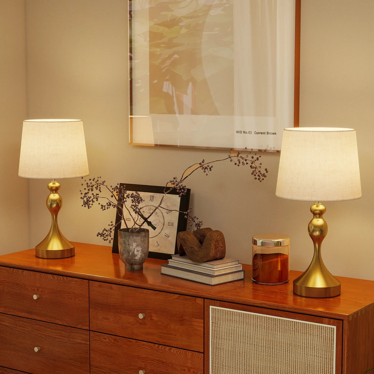 Pair of bedside table lamps with beige linen shades and gold-tone bases on dresser