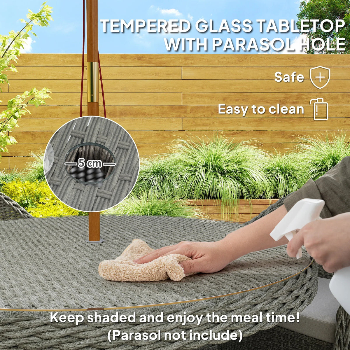 Grey woven rattan chair with thick light cushion, beside round glass table with parasol hole