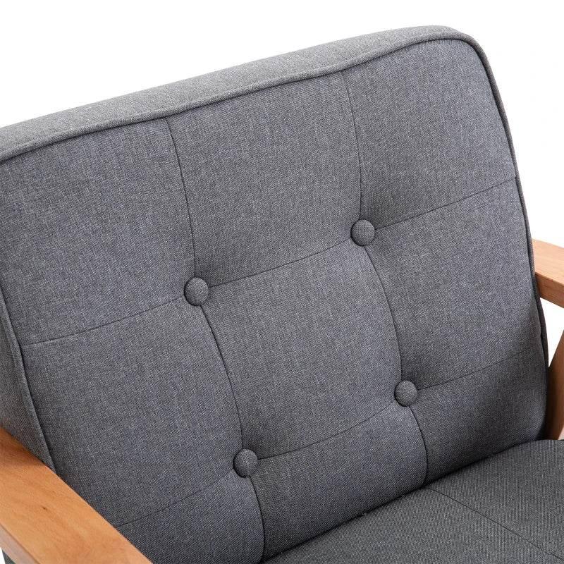 Close-up of grey tufted accent chair back with round buttons and textured fabric.
