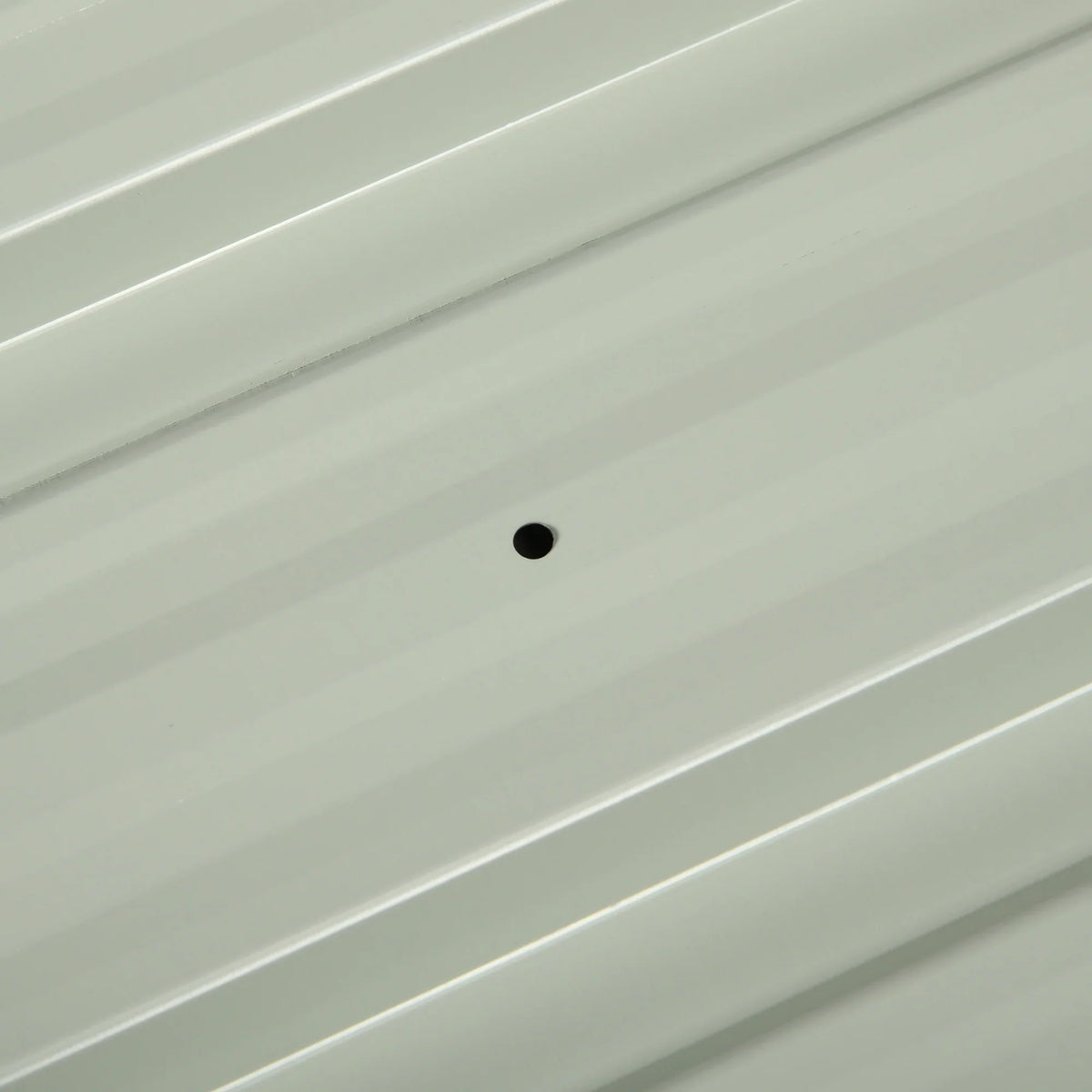 Light grey corrugated galvanized roofing sheet with small round fixing holes