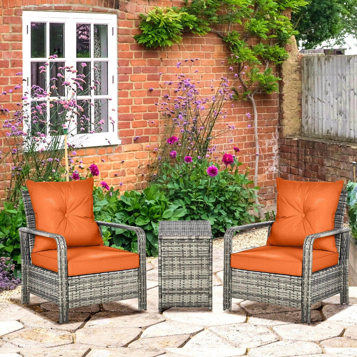 3-piece patio bistro set with two grey wicker chairs and orange seat cushions