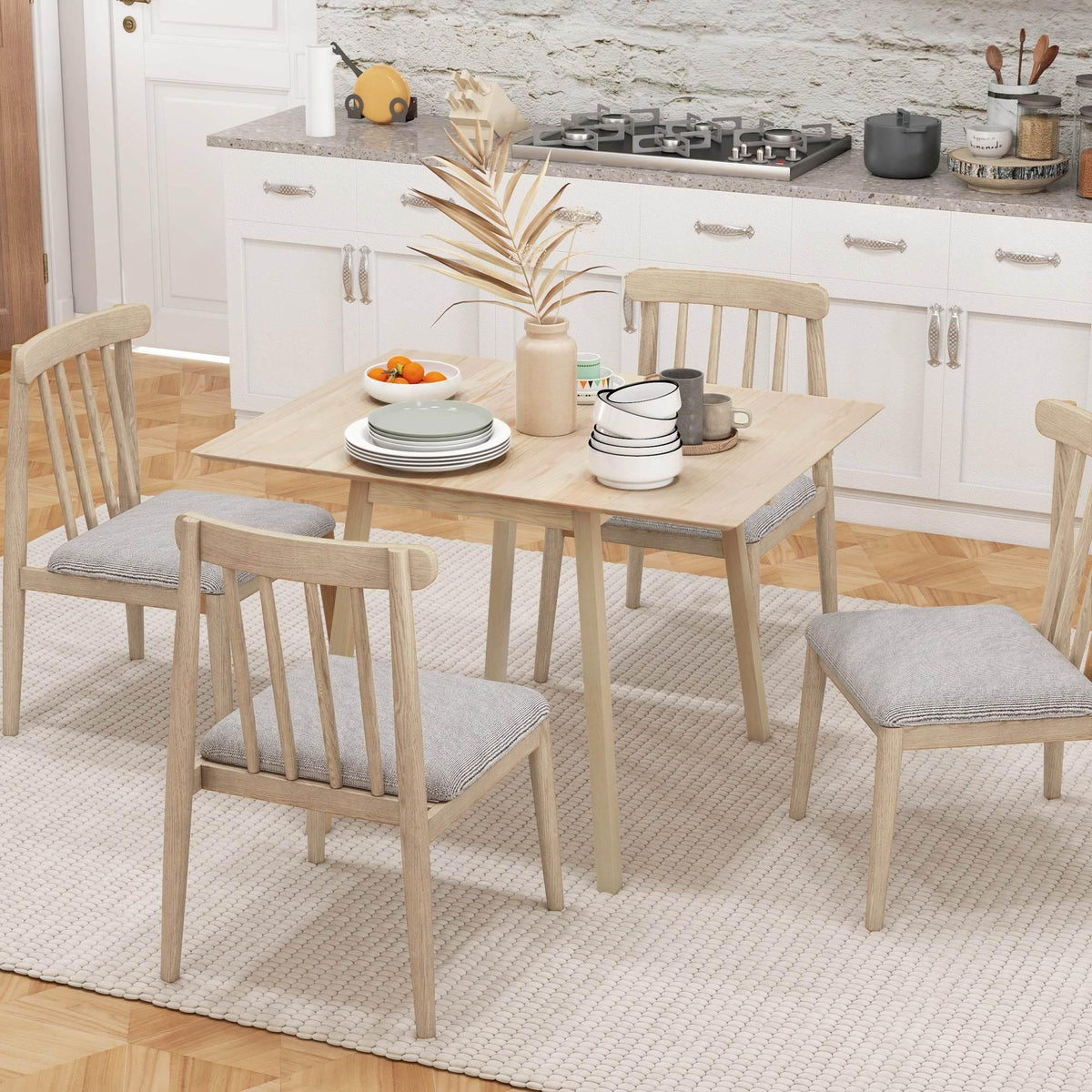 Natural pine drop-leaf dining table with four chairs and dinner settings