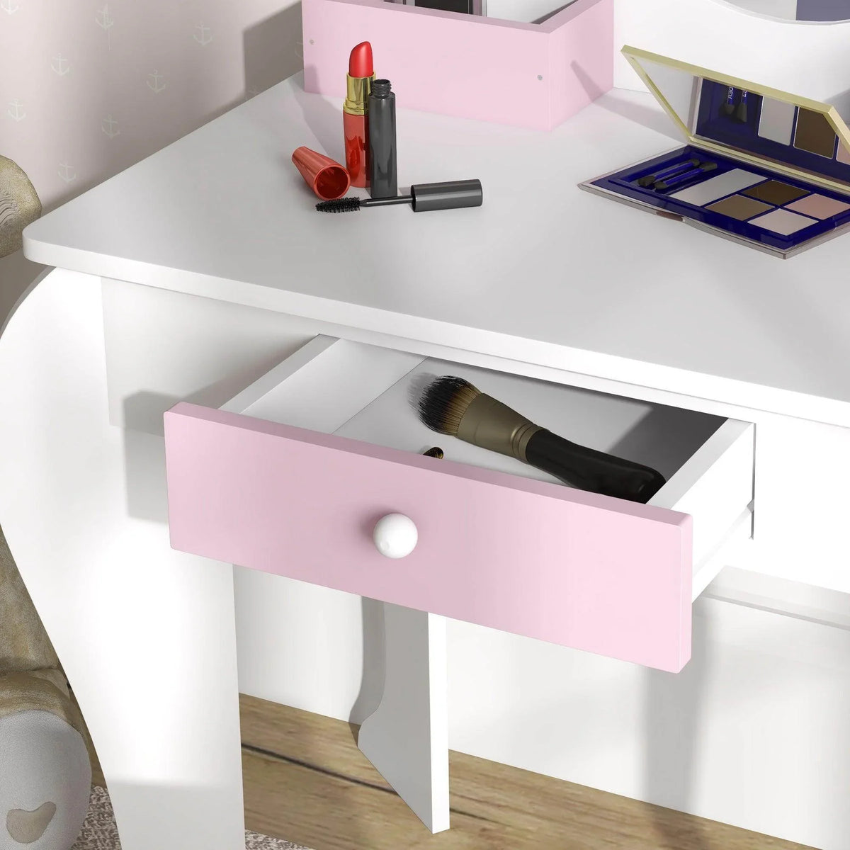 Kids vanity table with pink drawer and open storage; makeup items arranged on top