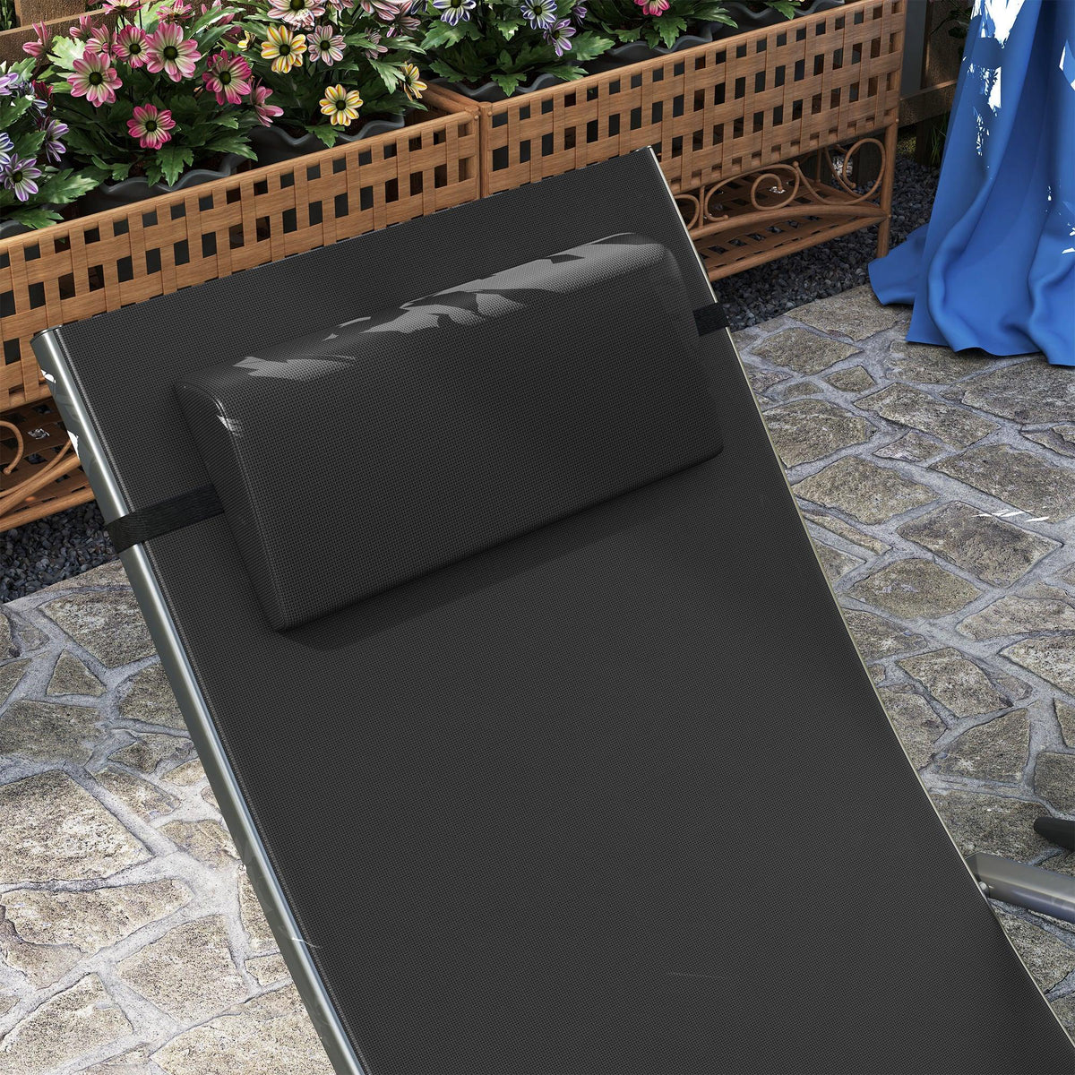 Black adjustable sun lounger with cushioned pillow on mesh back and seat