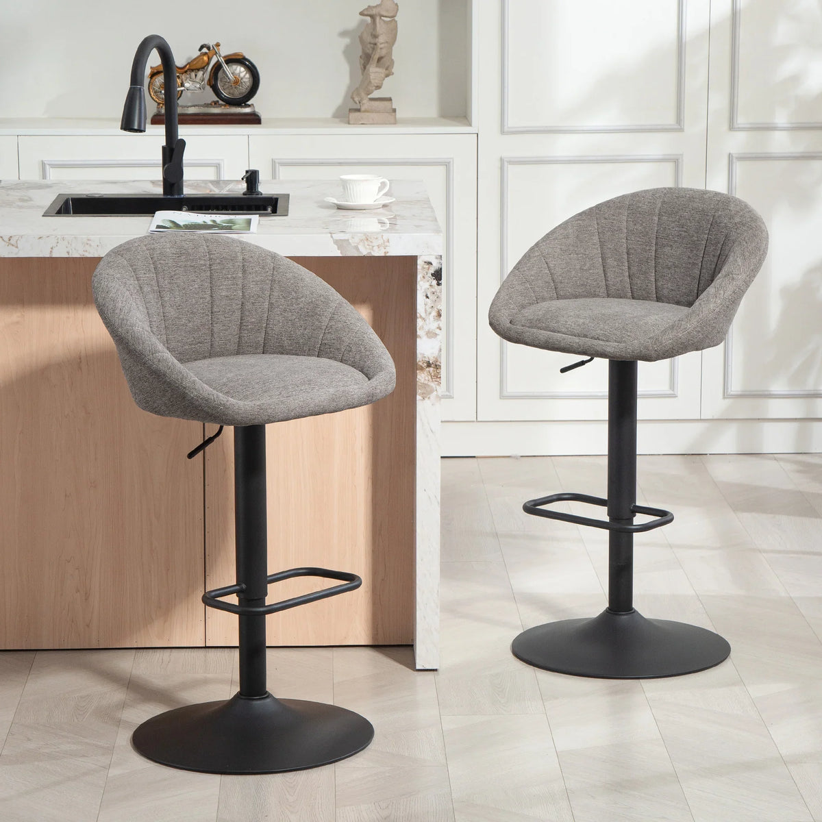 Set of two grey fabric bar stools with rounded seat, black base, and 360° swivel