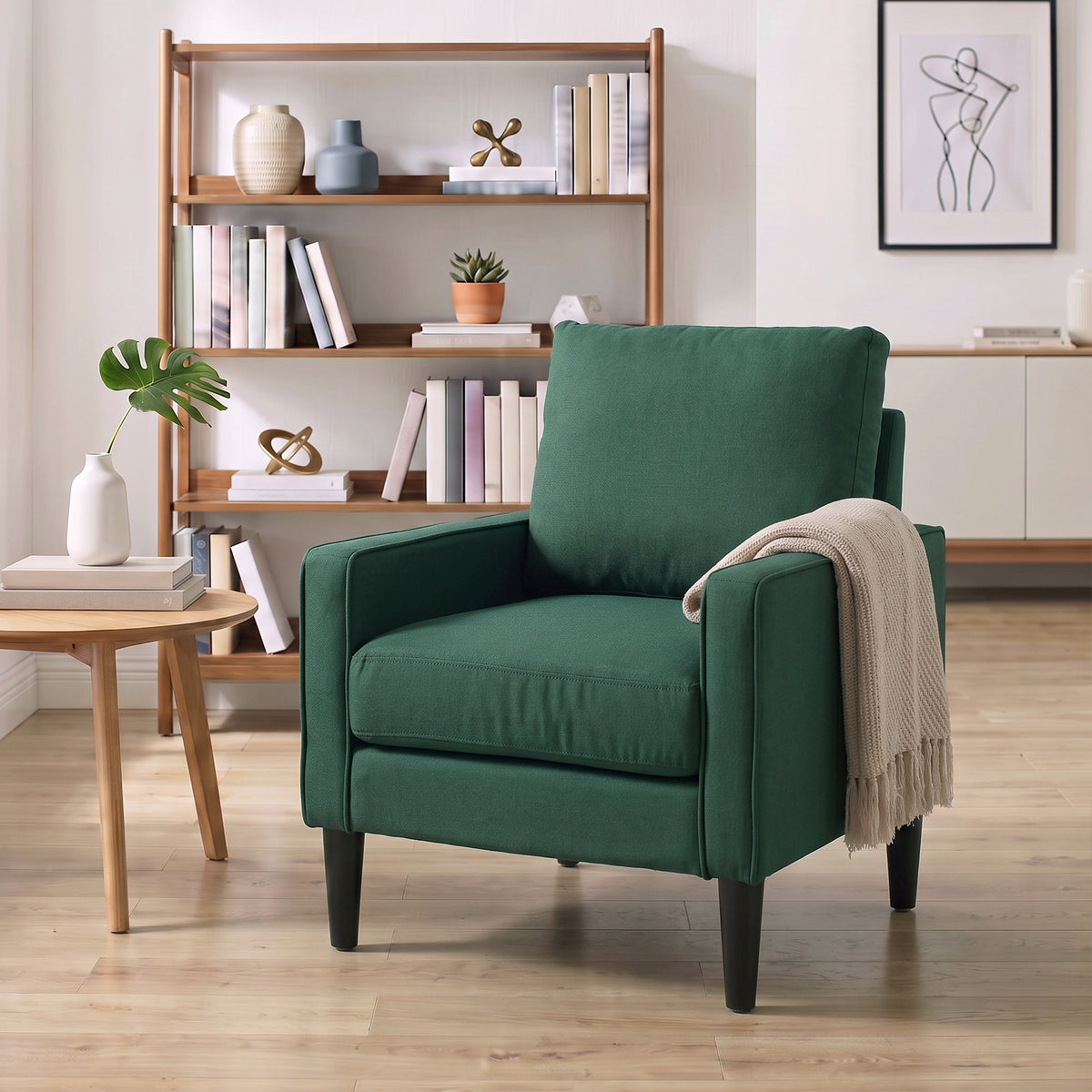 Dark green armchair with plush seat cushion and back pillow, finished with piping trim