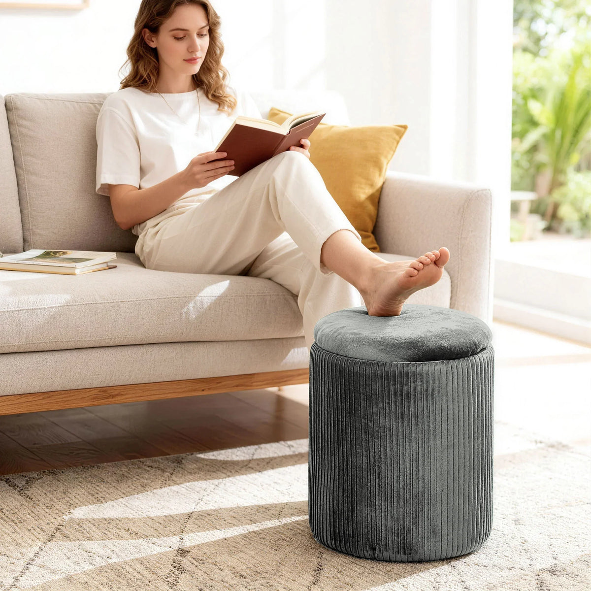 Grey ribbed round storage ottoman footstool with cushioned top on living room floor