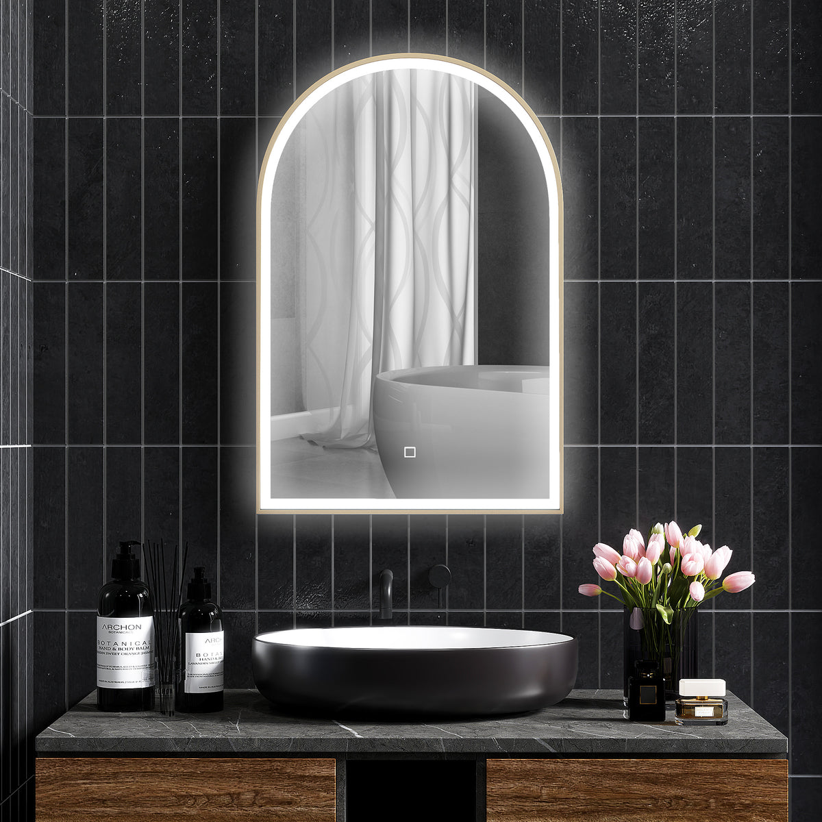 Arched gold LED bathroom mirror above black sink on tiled wall