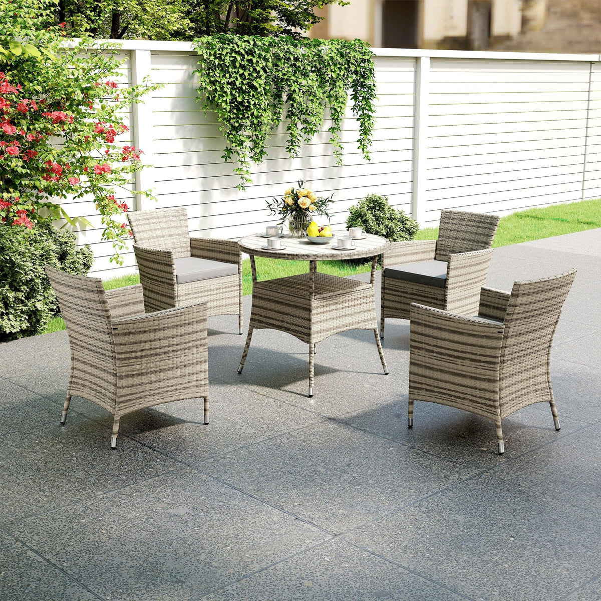 Grey woven rattan patio set with four armchairs and round two-tier table, outdoor angle