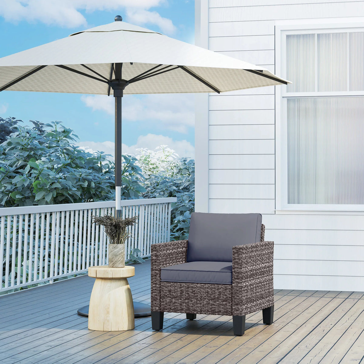Grey rattan outdoor armchair with dark grey cushions, on a wooden deck