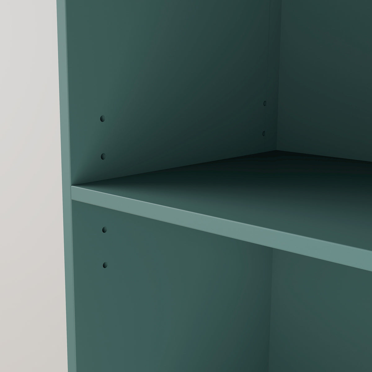Light green bookcase interior with open shelf panel and peg holes on back