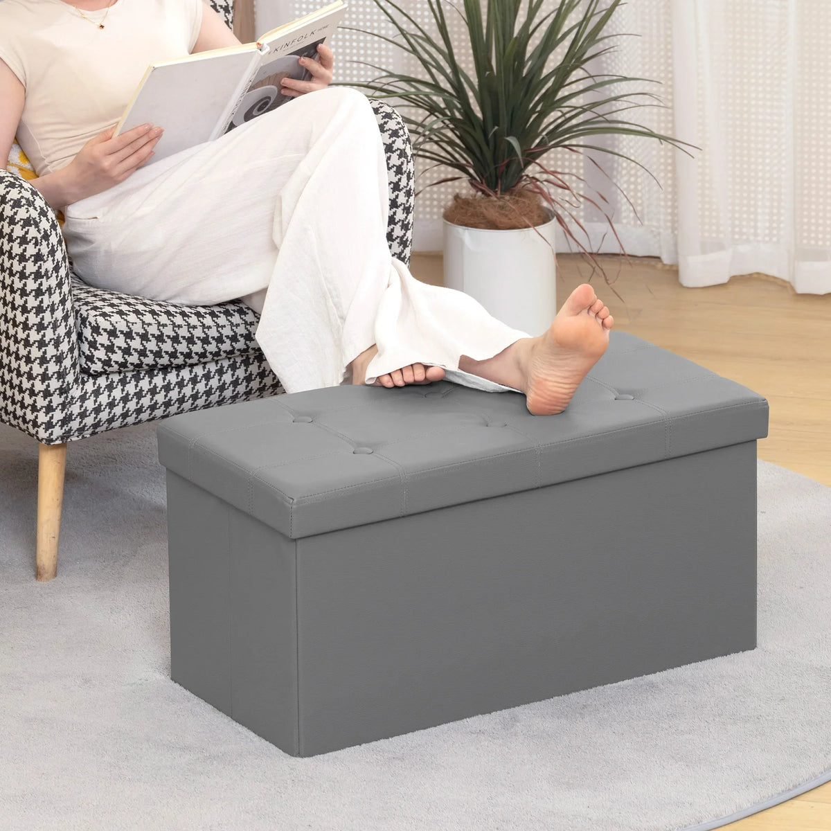 Grey storage ottoman bench as footrest with padded, button-tufted lid