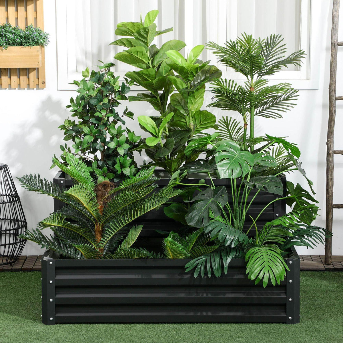 Dark gray two-tier raised garden planter with metal slat panels, filled with soil and lush plants