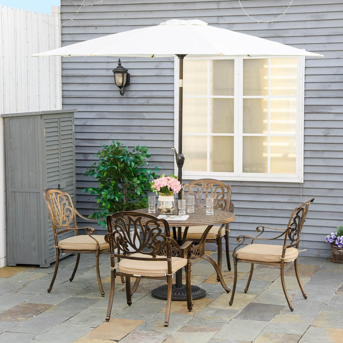 Outdoor dining set with umbrella and four chairs, featuring beige seat cushions
