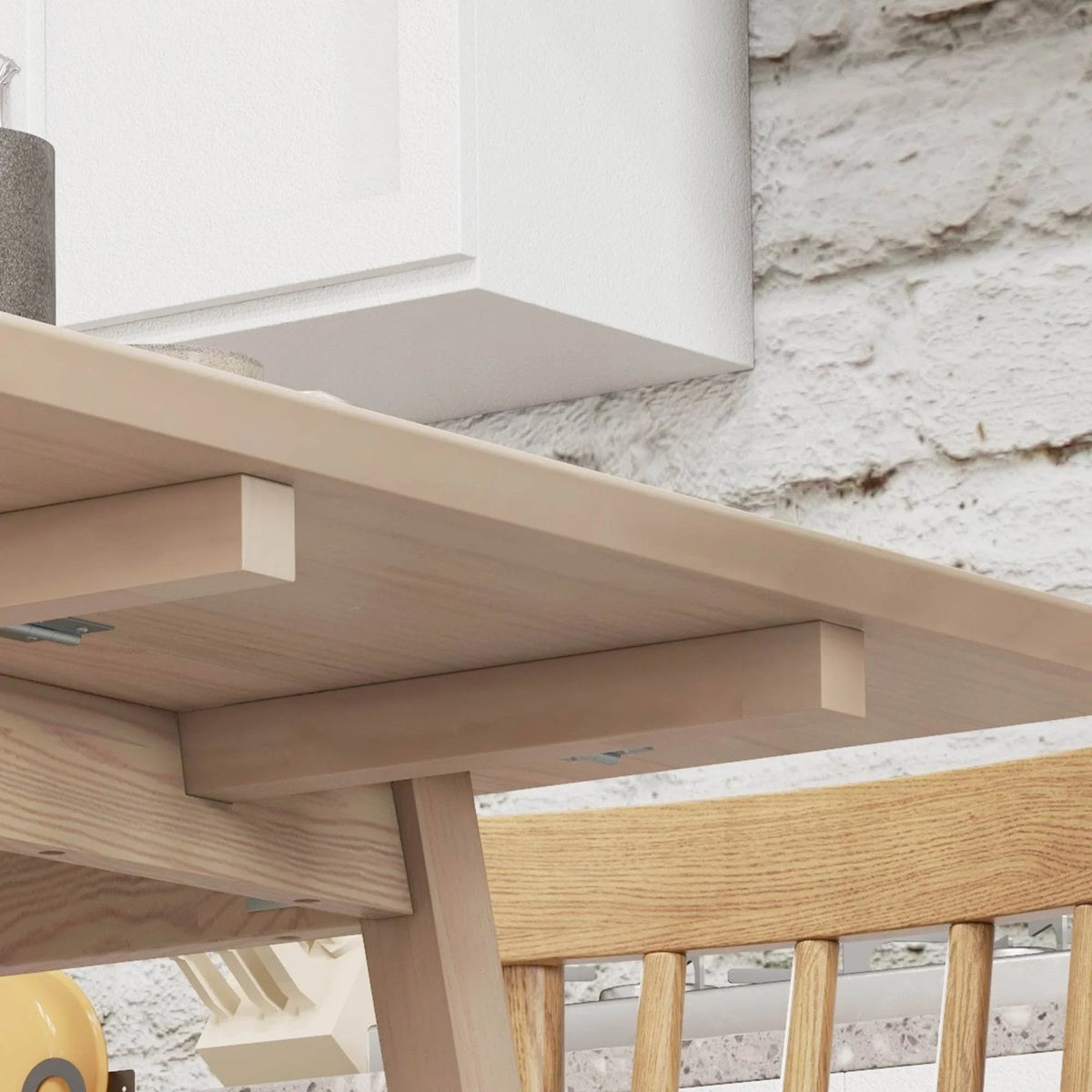 Natural pine drop-leaf table underside with supporting hinges and leaf frame