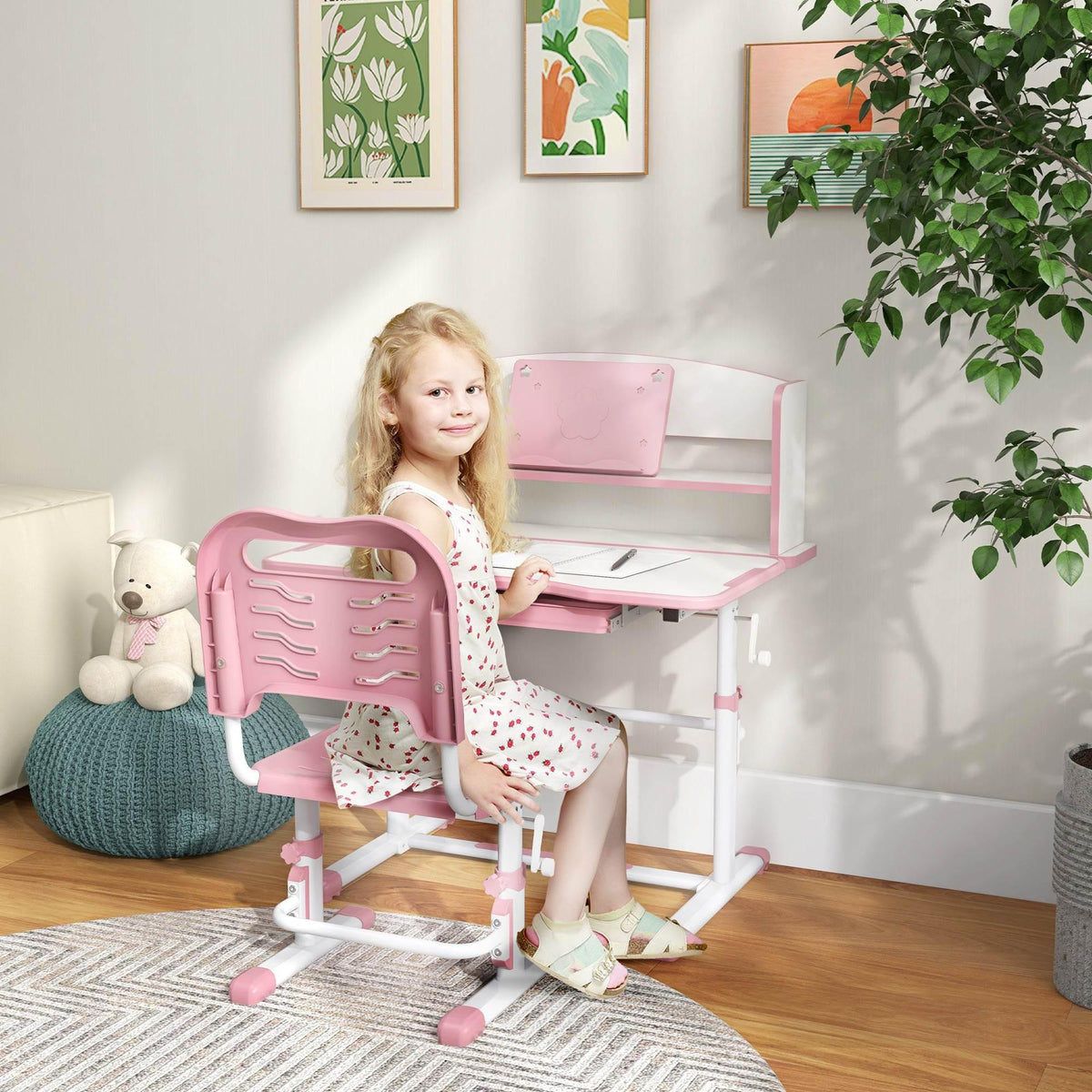 Pink kids study desk and chair set with drawer, shown with child seated