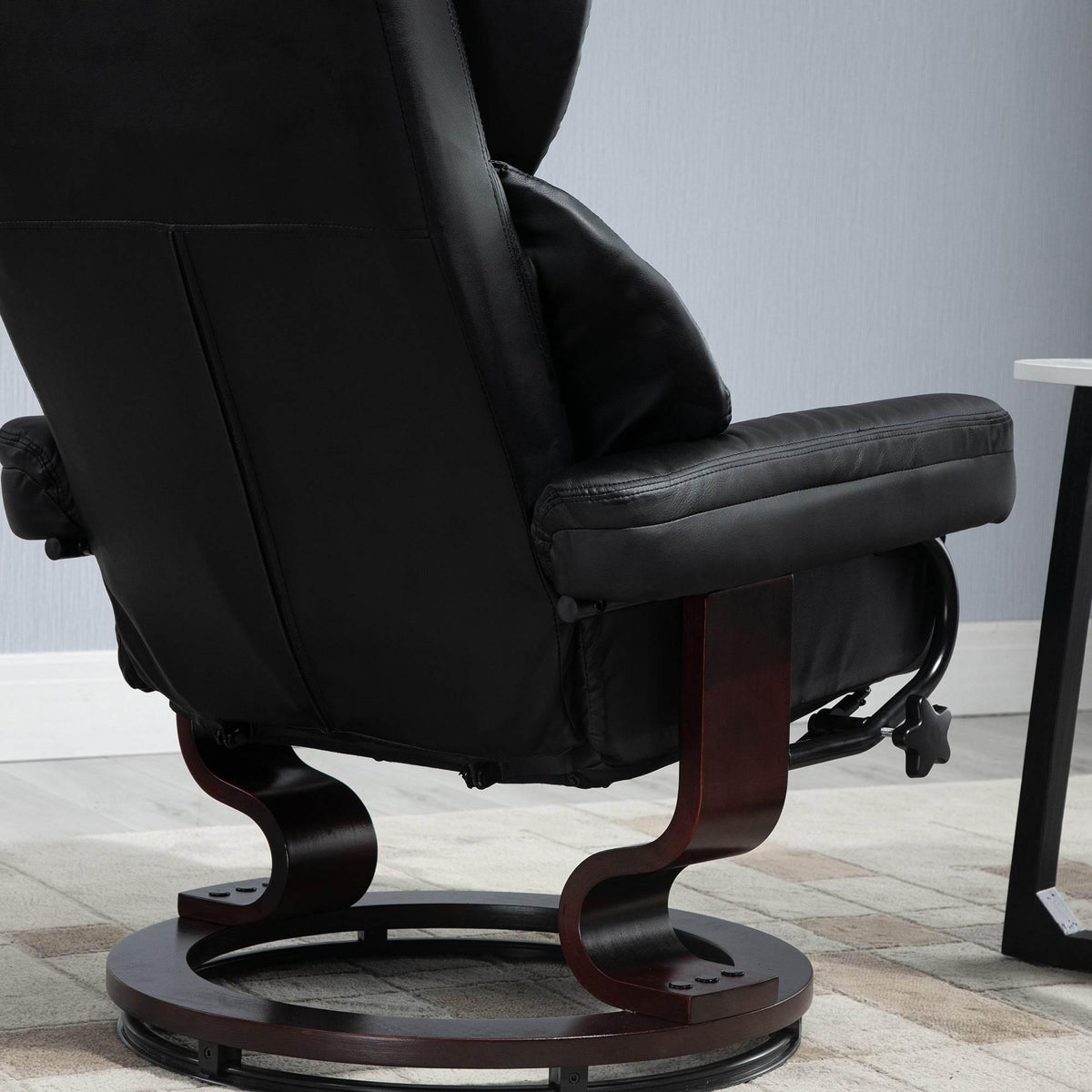Black reclining swivel chair with padded arms and round base with wood accents