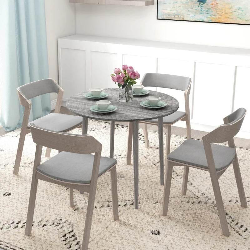 Grey round dining table with folding drop leaf and four wood legs, set for 4