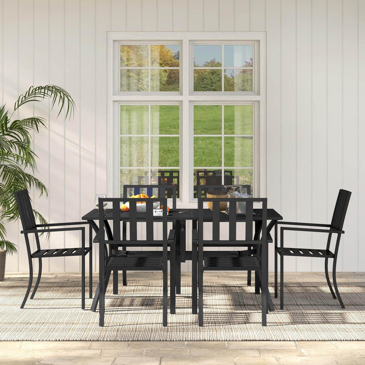 Black 6-seater outdoor dining set with table and six chairs on patio outside.