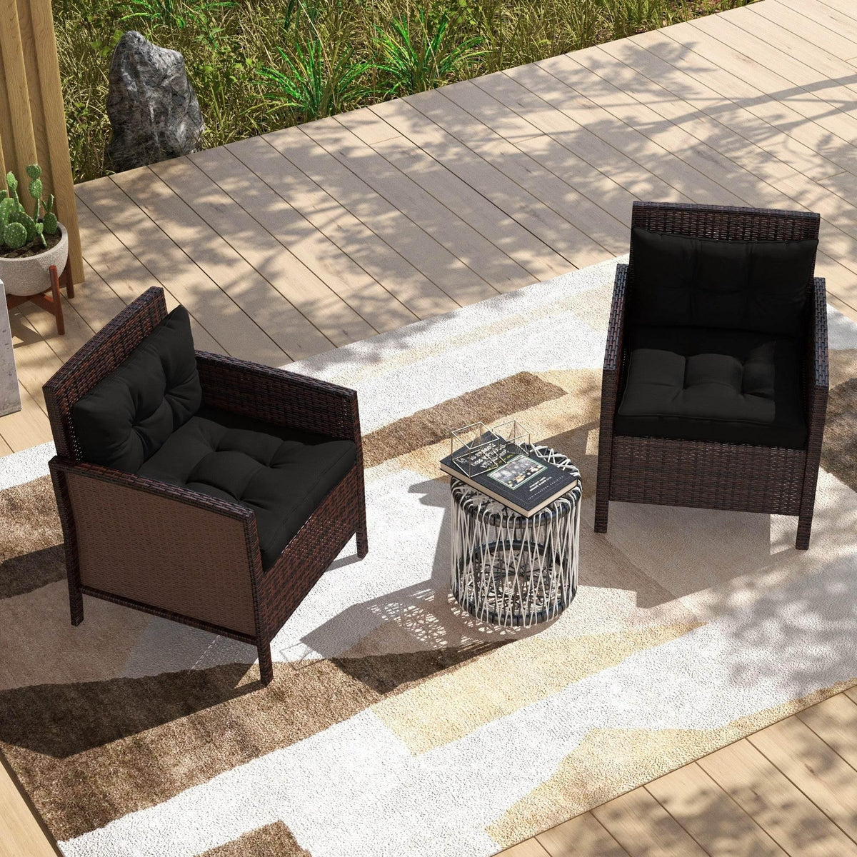 Outdoor seating set with two armchairs featuring black padded cushions