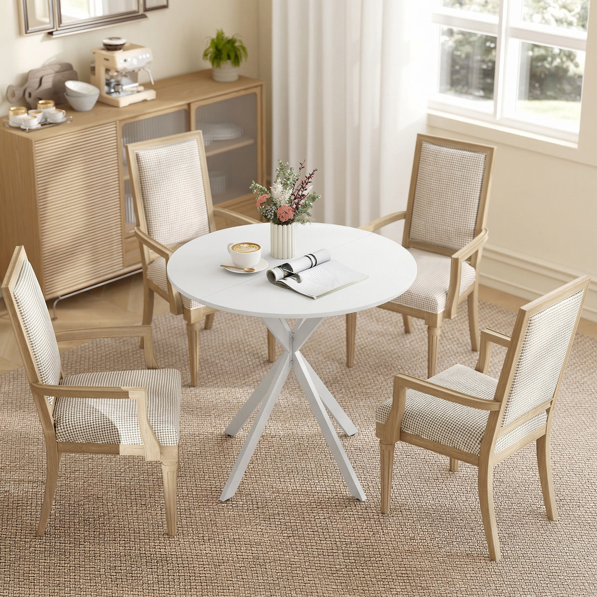 White round dining table with X-shaped legs between four beige upholstered chairs