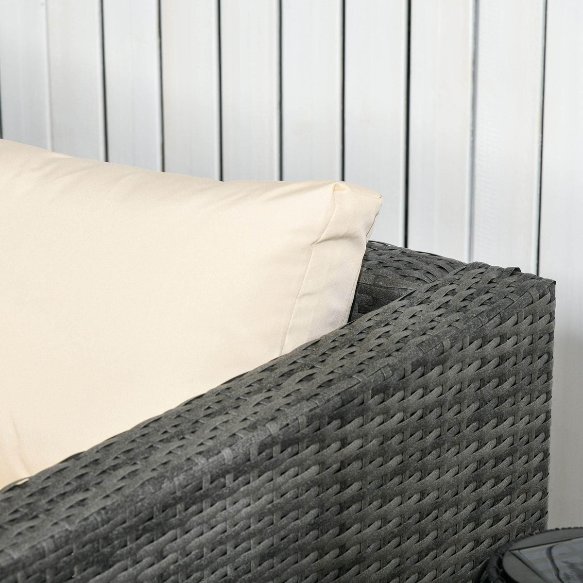 Beige cushion on a dark gray woven rattan patio sofa corner