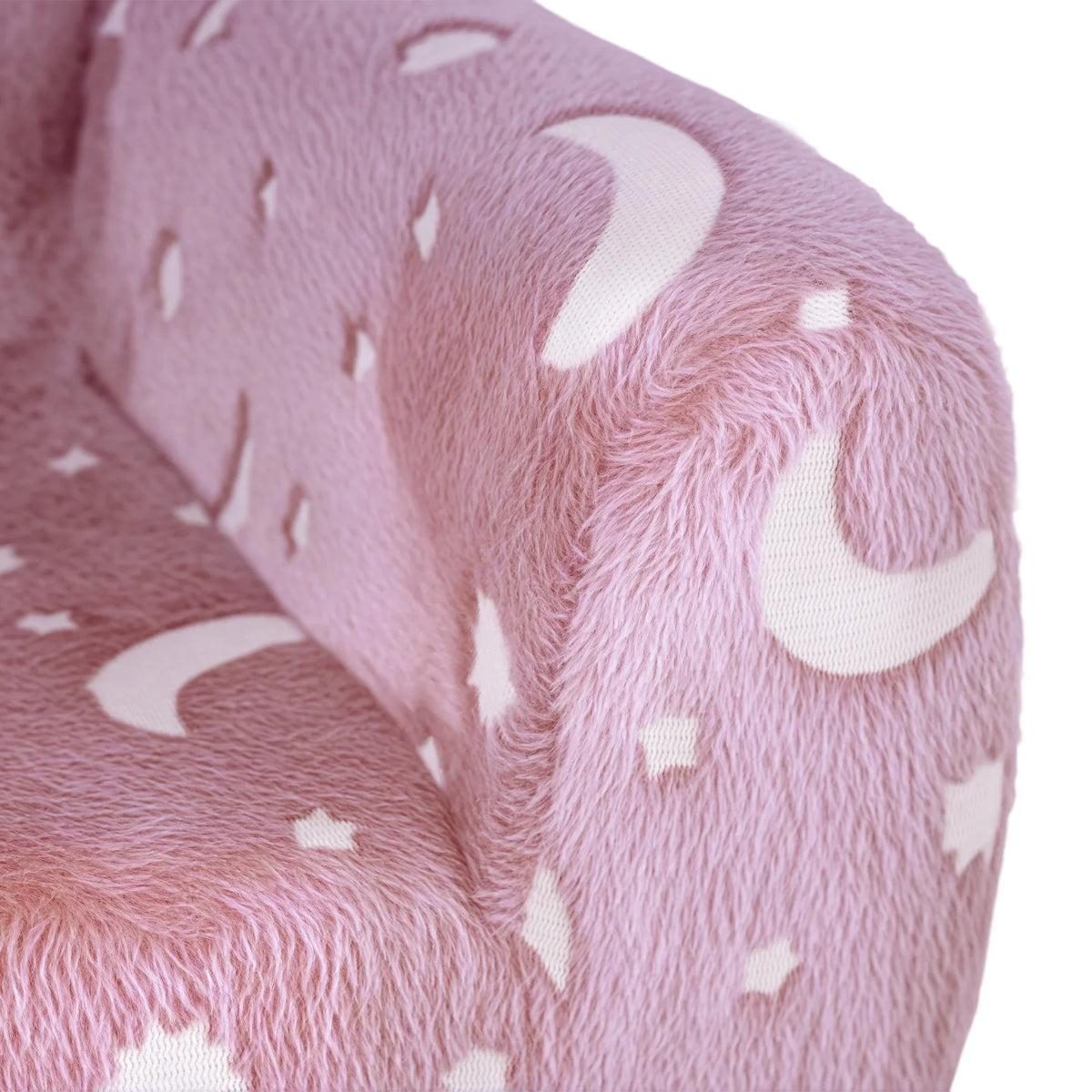 Close-up of pink plush kids armchair fabric with white star, moon, and sparkle patterns