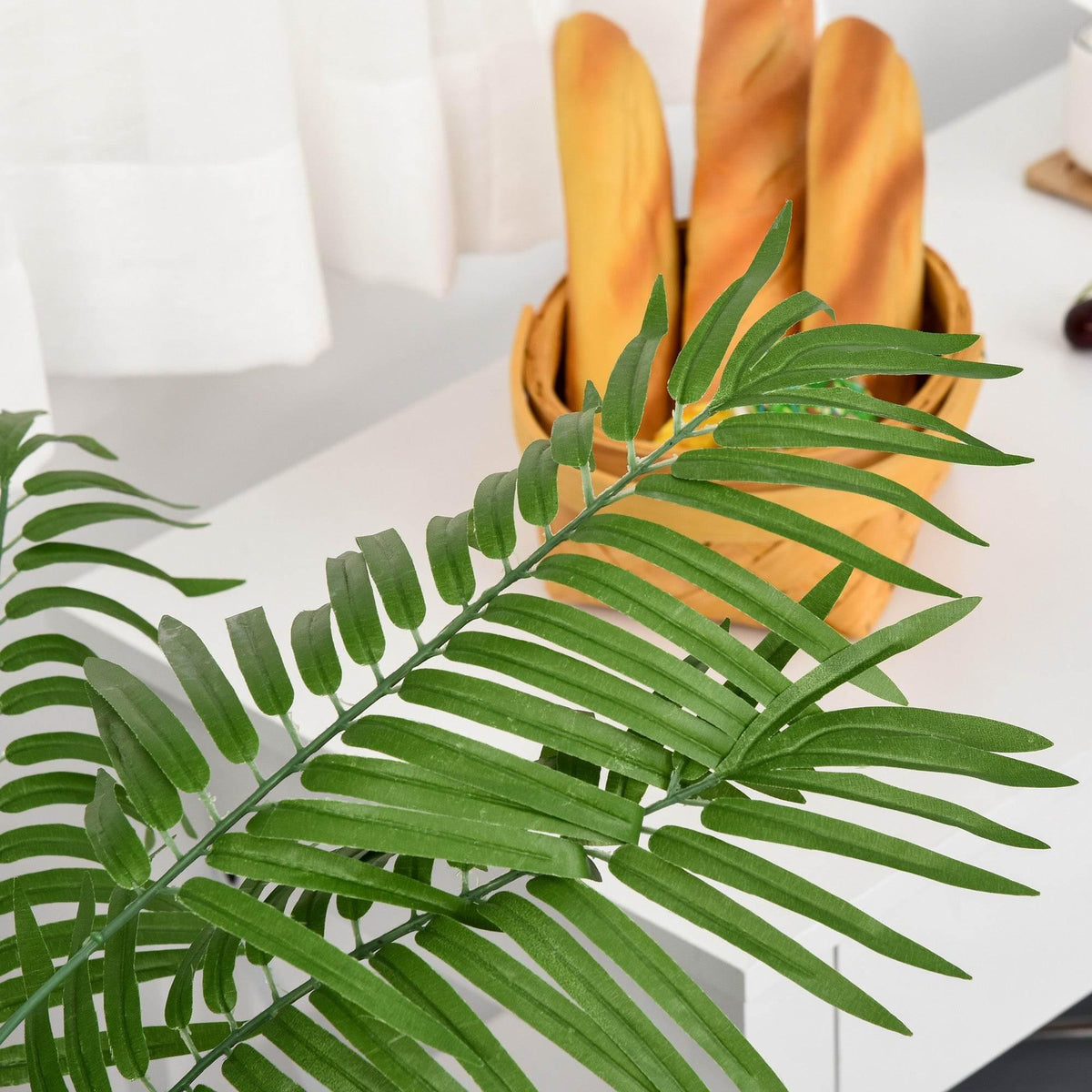 Close-up of artificial palm fronds with detailed green leaflets and faux texture