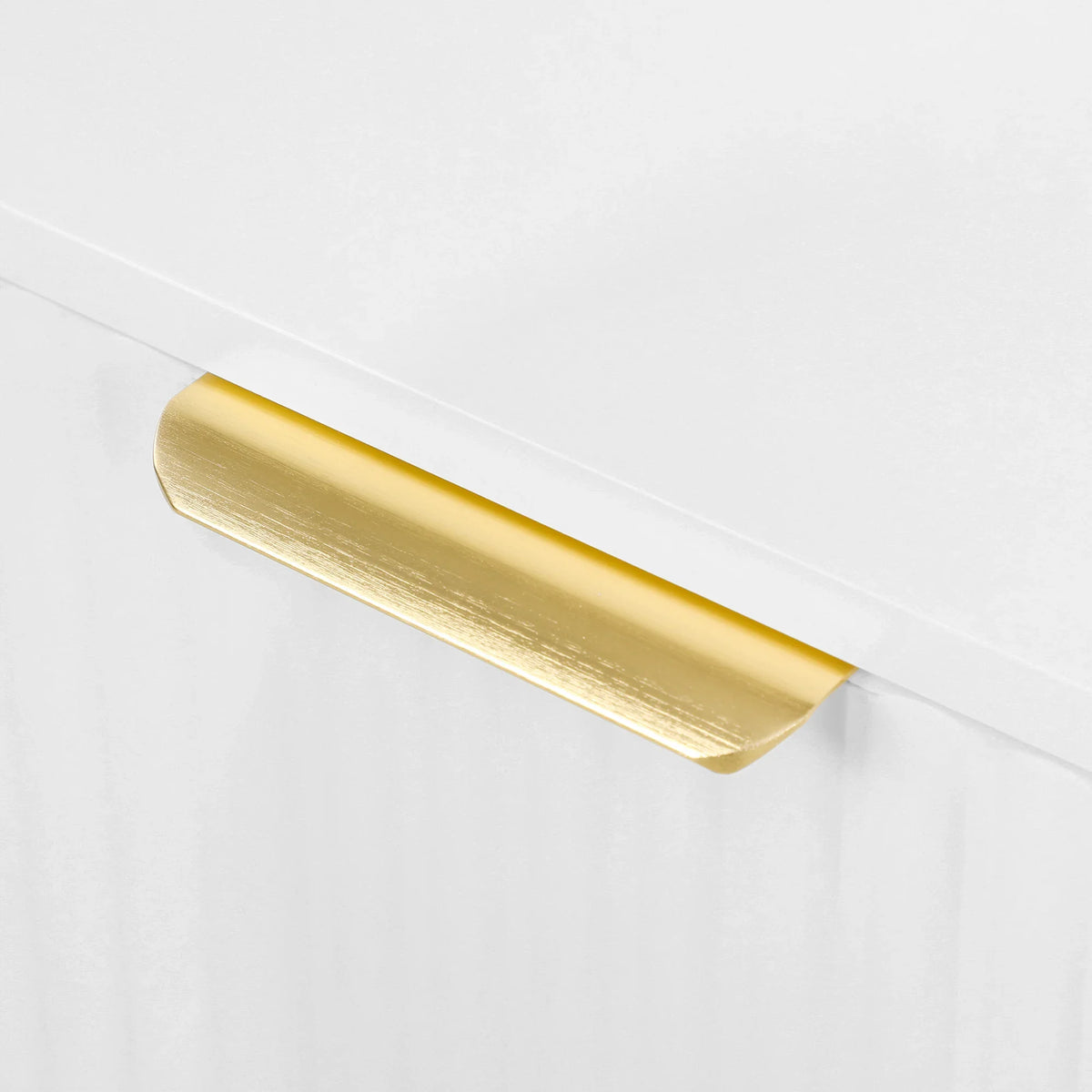 Gold metal base trim along the underside of a white cabinet sideboard