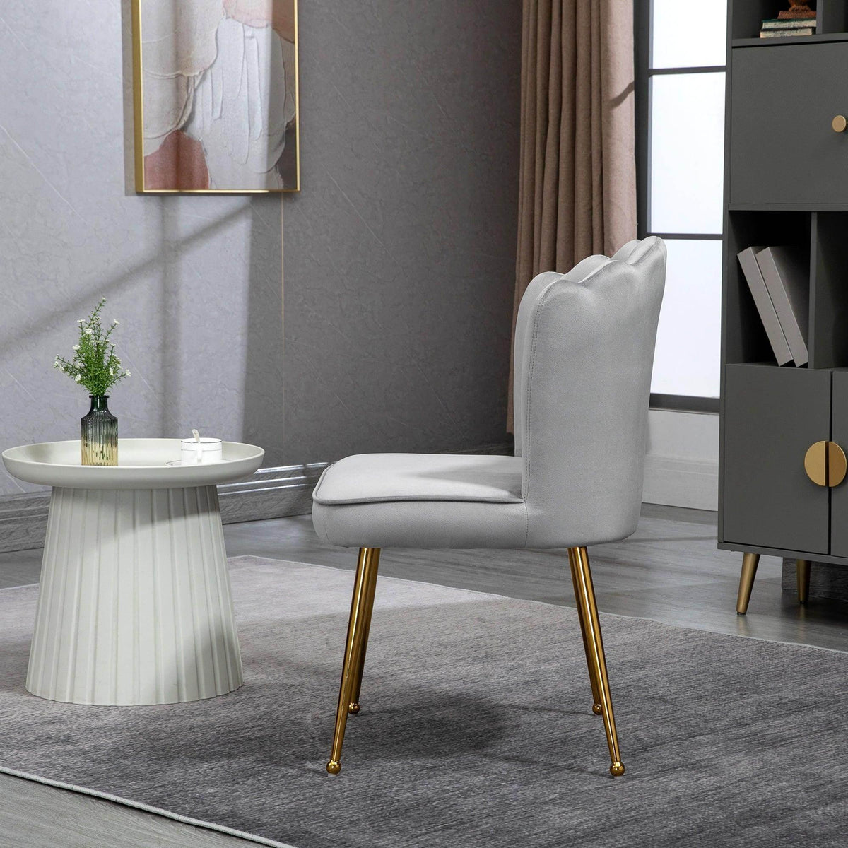 Grey velvet accent chair with curved shell back and gold metal legs