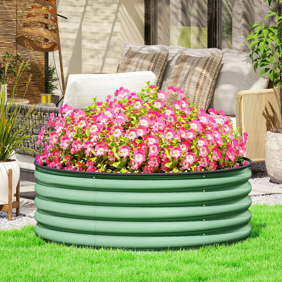 Light green round raised garden bed with wavy steel sides, holding pink flowers
