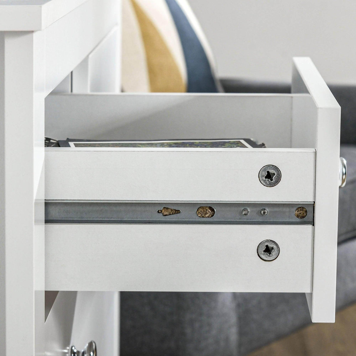 Open drawer of white 5-drawer chest with metal hardware and storage space.