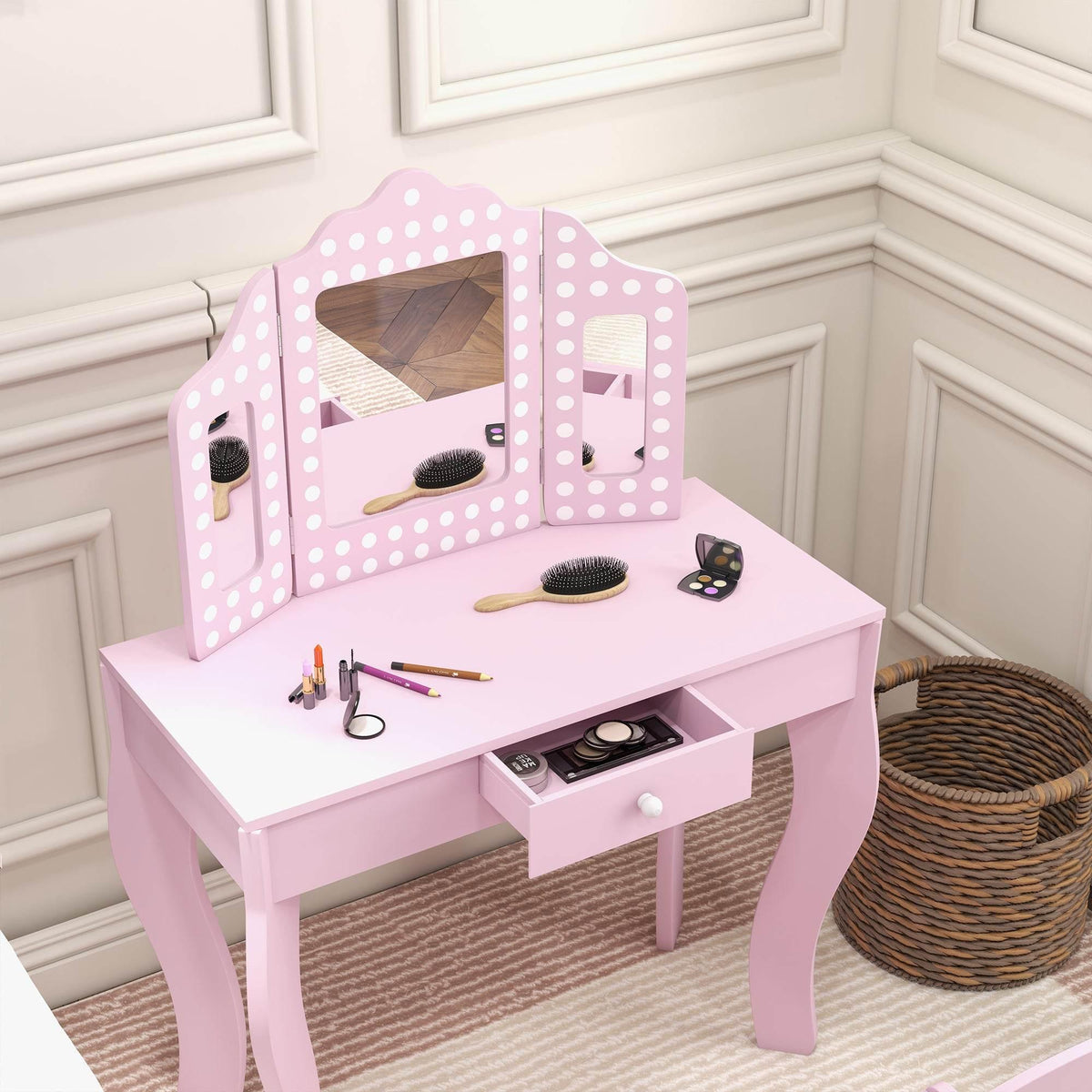 Pink kids vanity table with tri-fold mirror, countertop accessories, and drawer