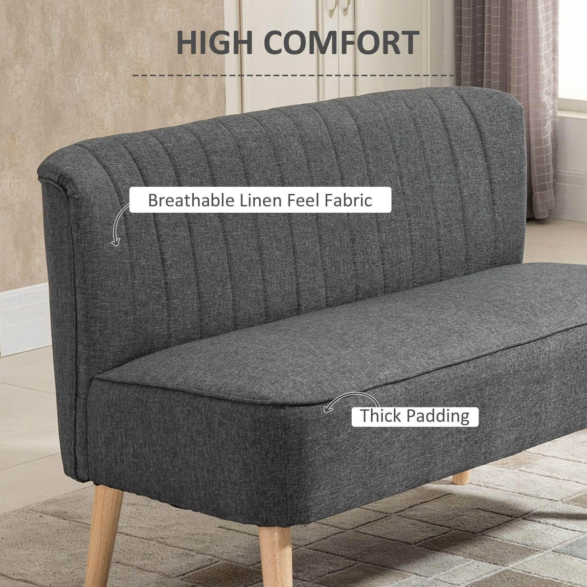 Grey upholstered sofa with tufted backrest and thick padded seat