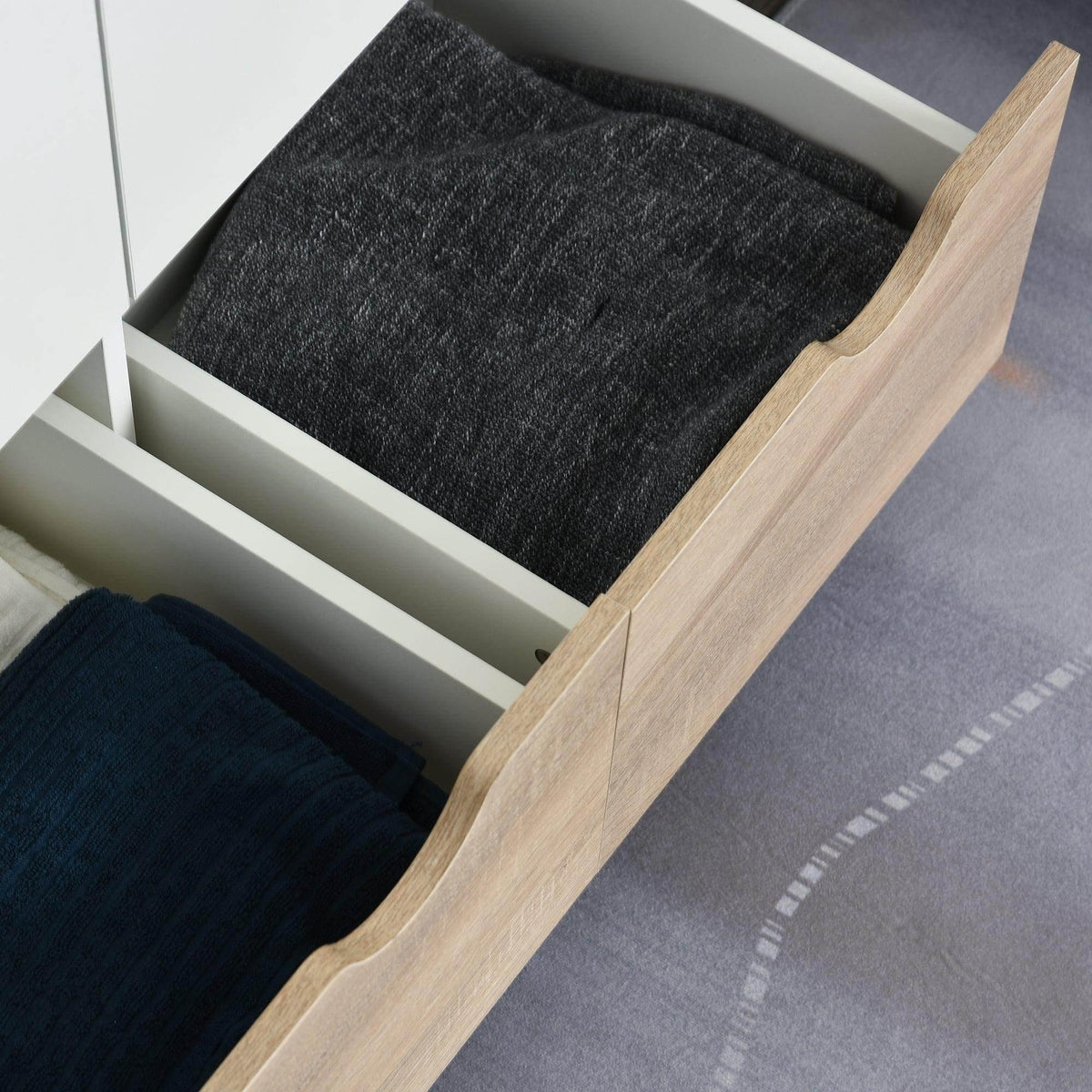 White open drawer with dark fabric insert and light wood drawer side panel