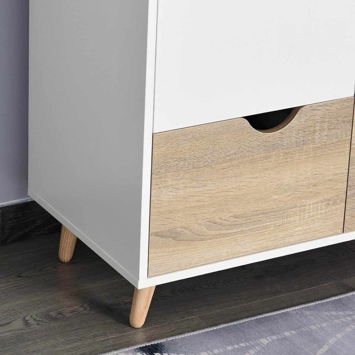 Close-up of white wardrobe base with light wood drawer front and curved handle cutout