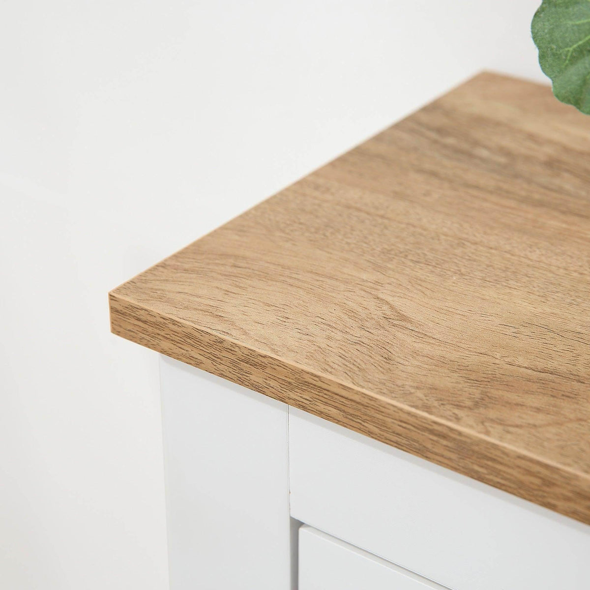 Light wood top panel on a white shoe cabinet