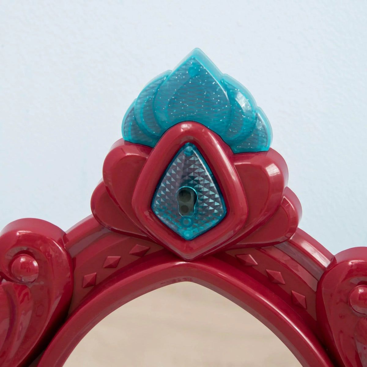 Decorative mirror crown detail in red and blue on kids dressing table