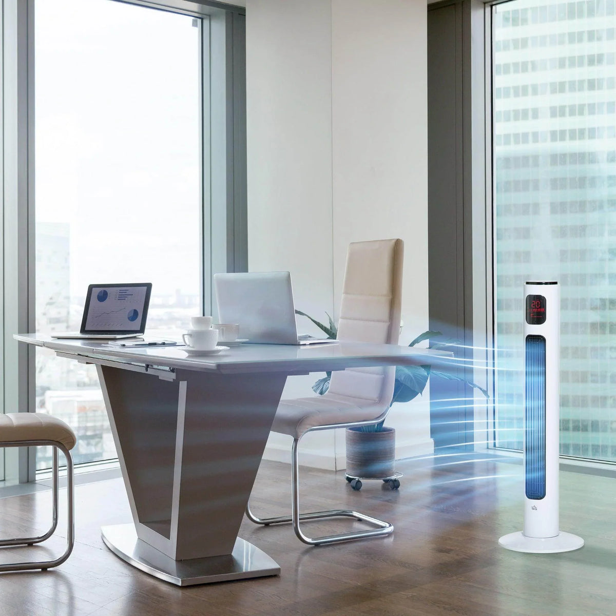 White tower fan on floor near desk, slim body with vertical grille