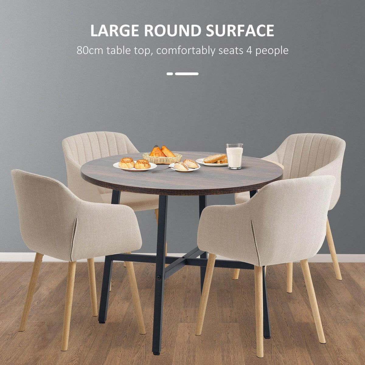 Round dining table with brown top and four upholstered chairs with black legs.