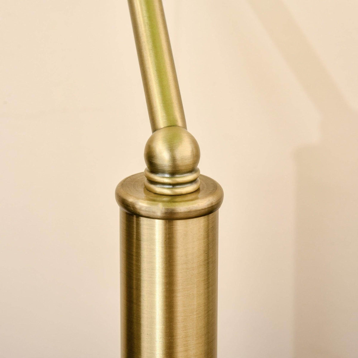 Close-up of bronze lamp stem and round base under green glass dome shade