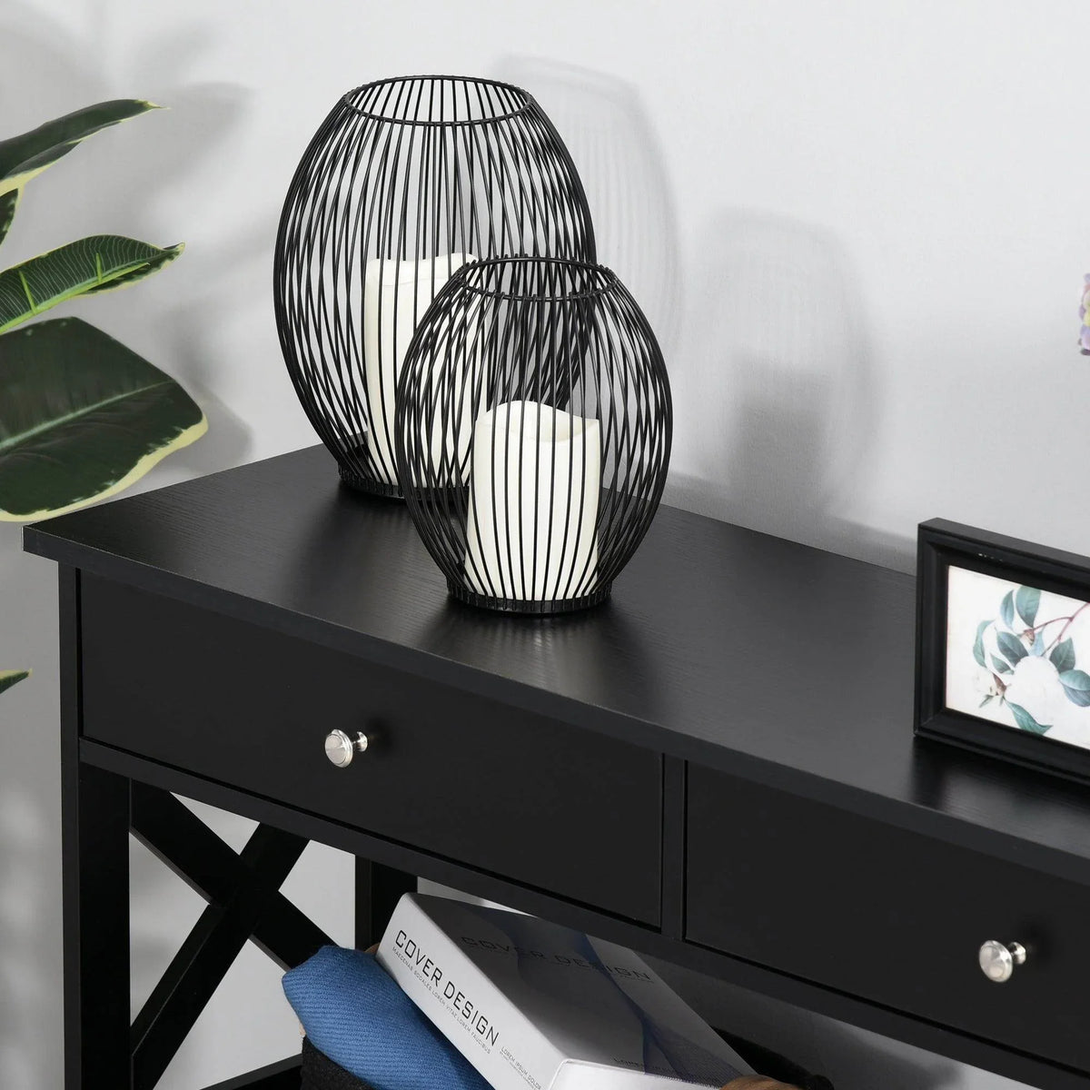Black console table with two front drawers and X-frame lower shelves.