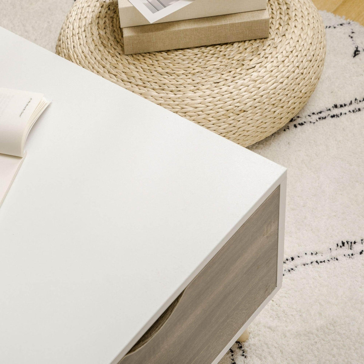 Corner view of white coffee table with dark side panel and open storage area