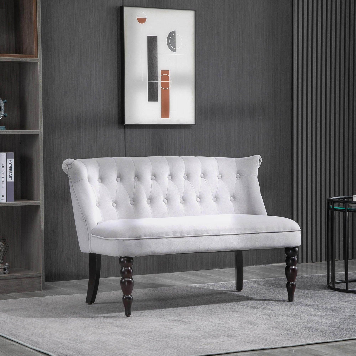 Light gray loveseat with button-tufted backrest and dark carved wooden legs