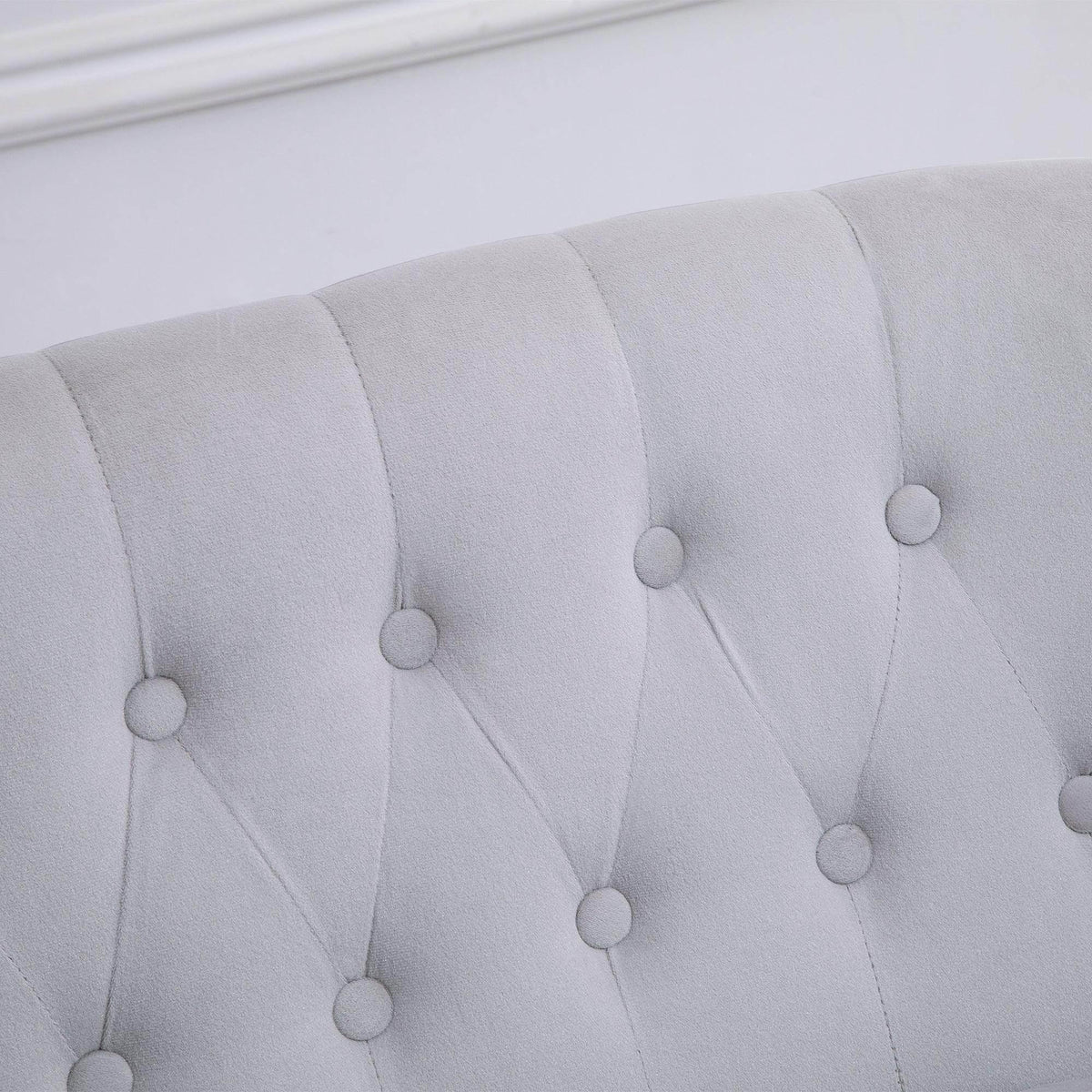 Light gray loveseat backrest detail with round button tufts