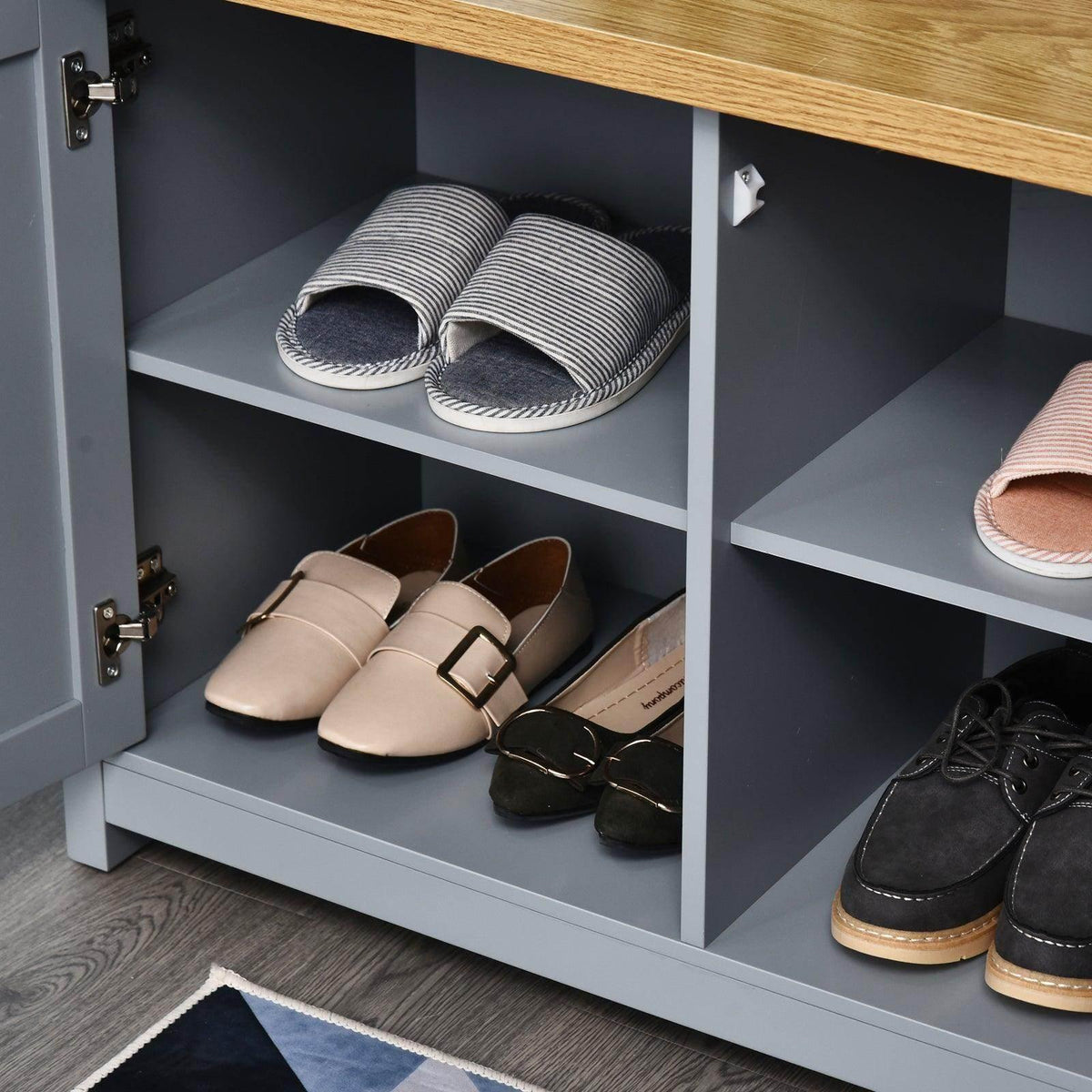 Open grey shoe cabinet interior with shelves holding slippers and shoes